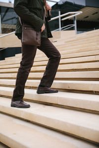 Low section of man walking on staircase