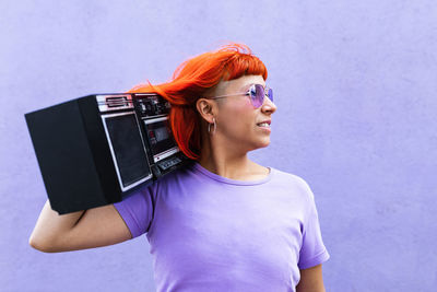 Portrait of smiling woman standing against wall