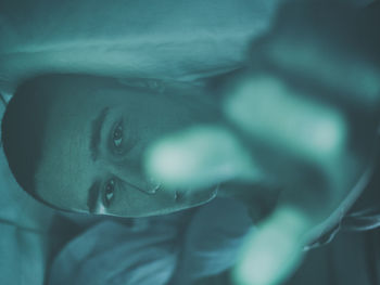 Close-up portrait of young man on bed