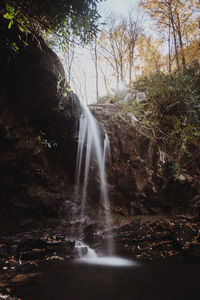 Scenic view of waterfall against sky