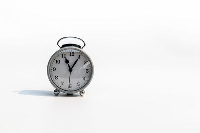 Close-up of clock on table against white background