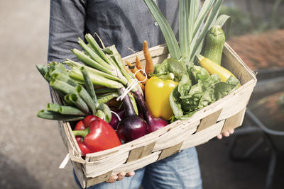 Midsection of woman carrying vegetables