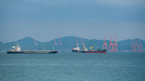 Boats in sea against clear sky