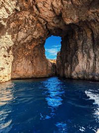 Rock formation in sea against sky