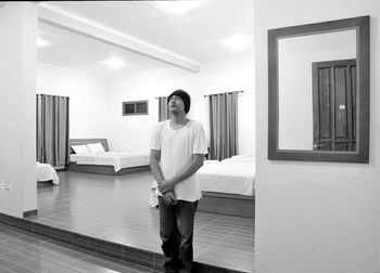 Thoughtful man looking up in illuminated hotel room