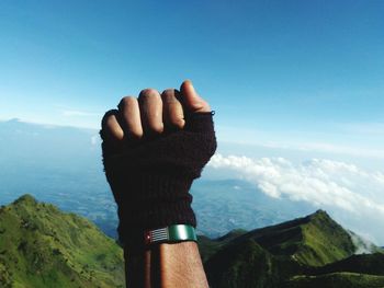 Midsection of person on mountain against sky