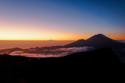 Scenic view of silhouette mountains against sky during sunset