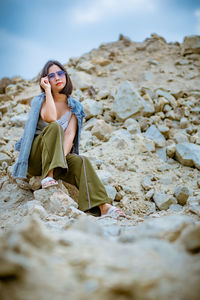 Young woman sitting on rock