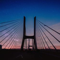 Low angle view of suspension bridge against clear blue sky