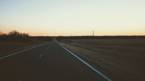 Road against clear sky during sunset