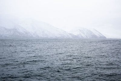 Scenic view of sea and snowcapped mountains against sky, iceland.