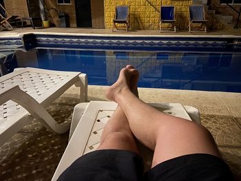 Low section of man lying on swimming pool