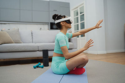 Portrait of young woman sitting on sofa at home