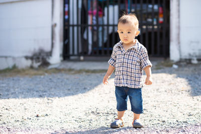 Full length portrait of cute boy standing outdoors