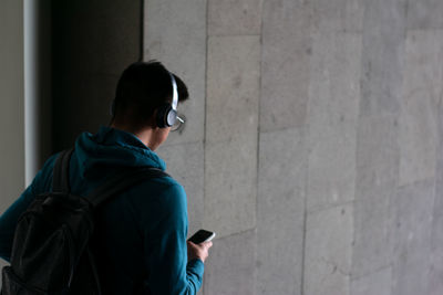 Unrecognizable person goes down stairs with his smartphone on the hand and copy space