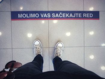 Low section of man standing on tiled floor