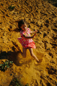 High angle view of girl playing on sand at beach