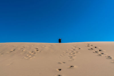 Scenic view of desert against clear blue sky