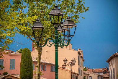 Low angle view of street light by building against sky