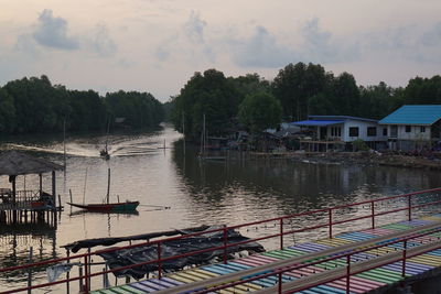 Scenic view of river by buildings against sky