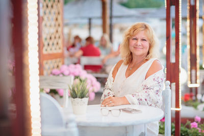 Portrait of woman sitting on the terrace of a beach cafe