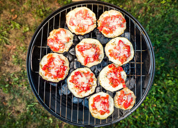 High angle view of pizza on barbecue grill in yard