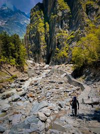 People walking on rocks against mountains