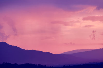 Scenic view of silhouette mountains against romantic sky at sunset