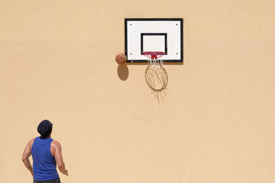 Rear view of man playing basketball
