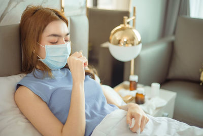 Portrait of woman drinking glasses on bed at home