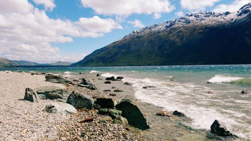 Scenic view of sea and mountains against sky