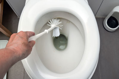 Cropped hand of person washing in bathroom