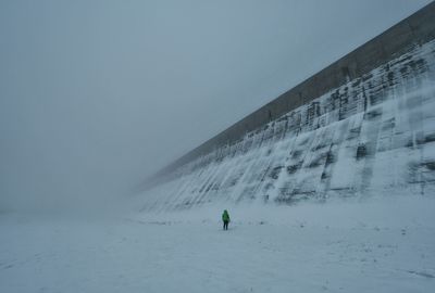 Rear view of man on snow against clear sky