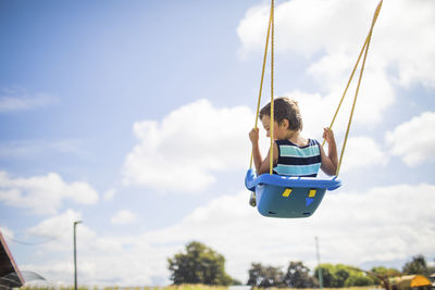 Low angle view of swing in playground against sky