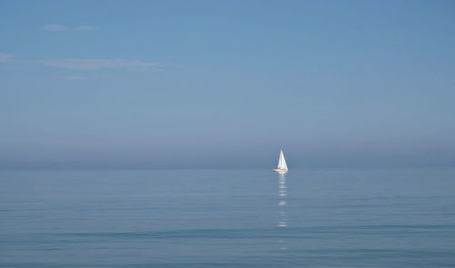 Sailboat sailing in sea against clear sky