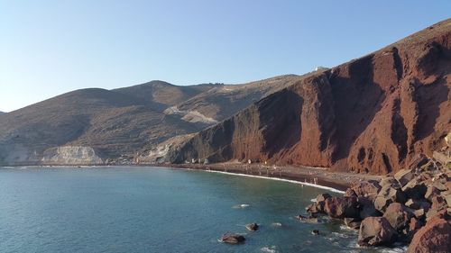 Scenic view of sea and mountains against clear sky