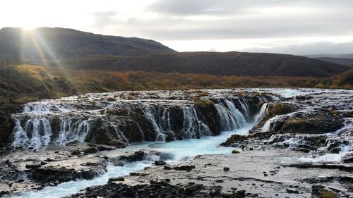 Scenic view of waterfall against sky