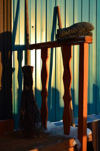 Broom by wooden railing against wall during winter