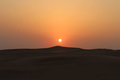 Scenic view of desert against sky during sunset