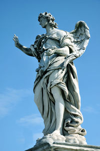 Low angle view of statue against blue sky