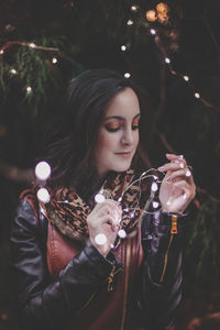 Close-up of beautiful woman holding illuminated lights