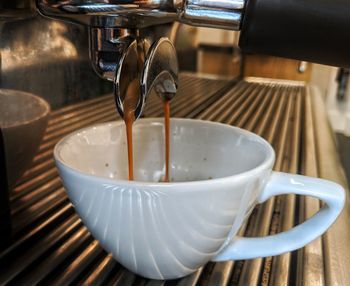 Close-up of espresso dripping from maker