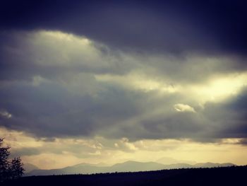 Silhouette of landscape against cloudy sky