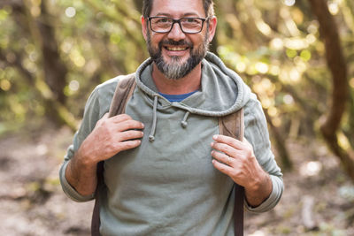 Portrait of man wearing hat standing against trees