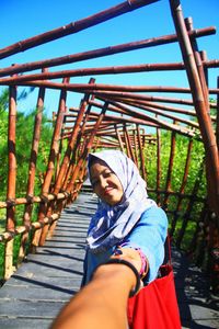 Close-up of boyfriend holding hand of woman while standing on footbridge