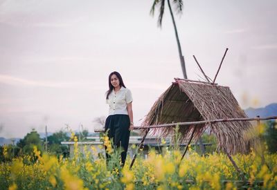 Rear view of woman walking on field against sky
