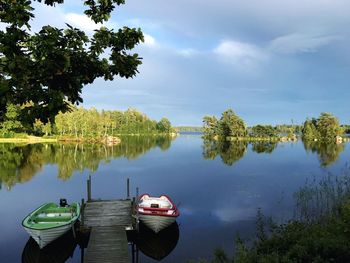 Boats moored in lake against sky