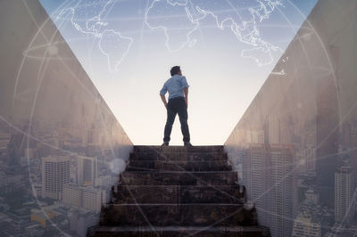 Rear view of man standing on staircase against building