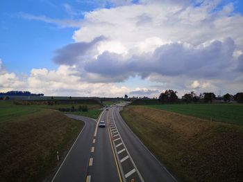 Empty road on field against sky