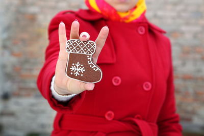 Midsection of woman holding gingerbread cookie during christmas